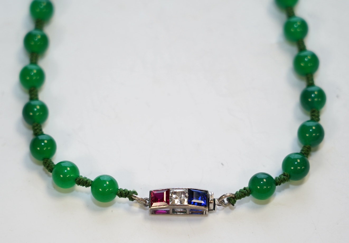 A single strand jadeite bead necklace, with simulated gemstone set clasp, 56cm. Condition - fair